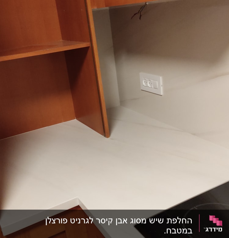 משטח שיש לבן במטבח עם כיריים חשמליות